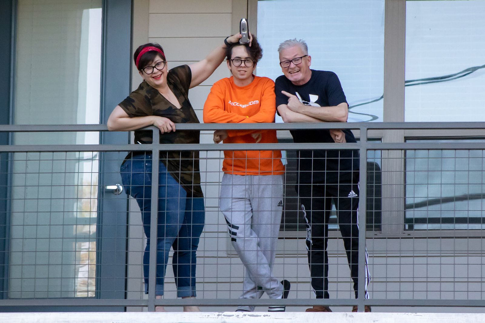 Two neighbors on a porch, one waving