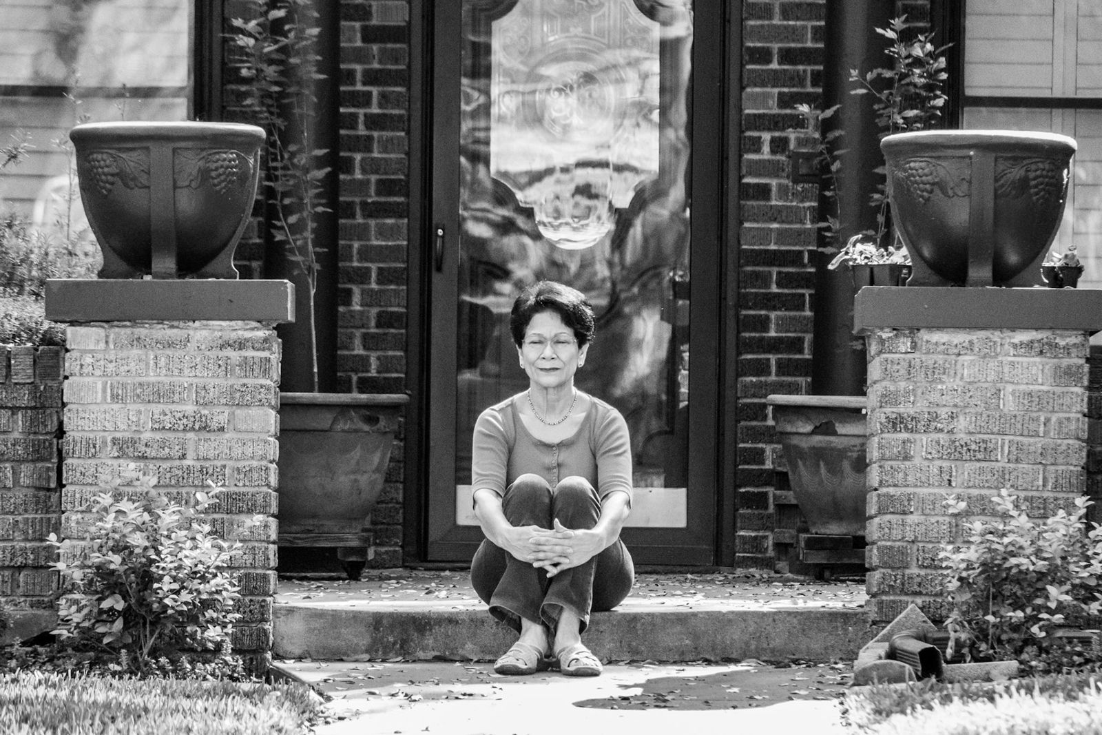 Woman with a dog on a front step, arms raised