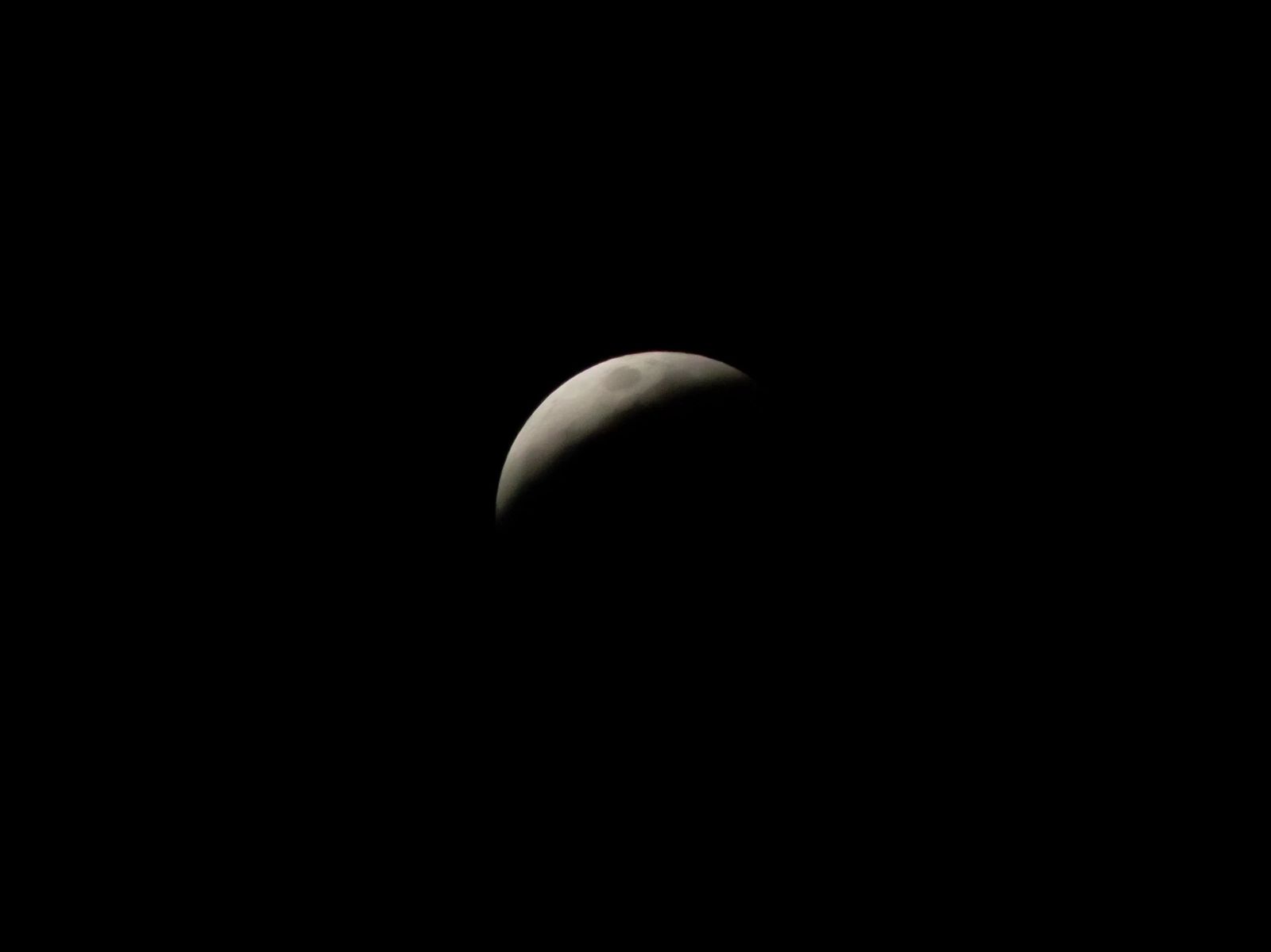 Eclipsed moon over black desert sky